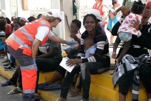 Personal sanitario atiende a las mujeres y niños llegados este domingo al puerto de Melilla.
